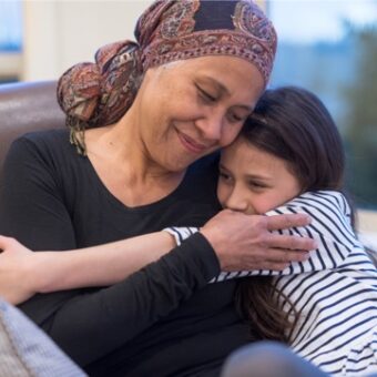 Female Cancer Patient Hugging Child