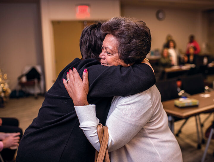 two women hug at cancer event